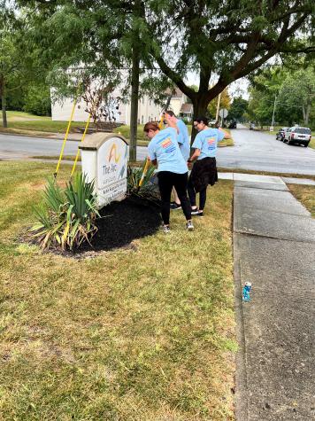 Group of people spreading mulch around a sign