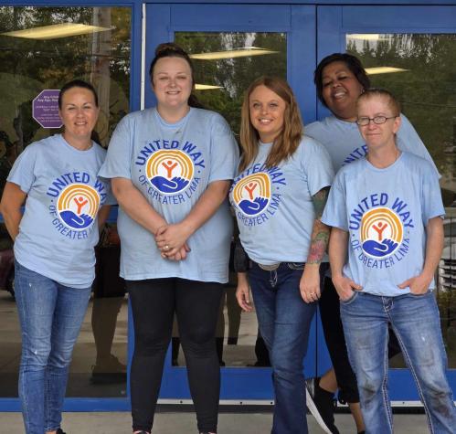 Group of people in United Way shirts in front of blue doors