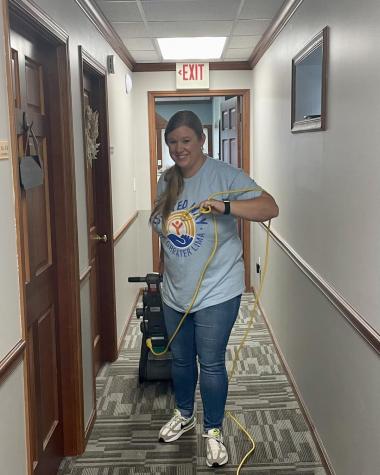 Women shampooing carpet in a hallway