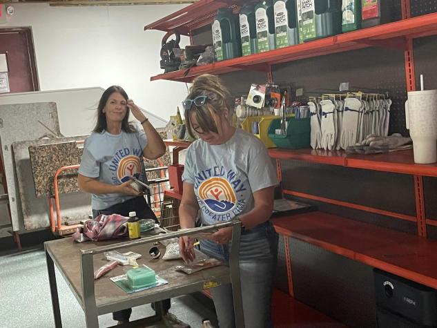 two ladies tagging hardware items to hand on hooks for sale