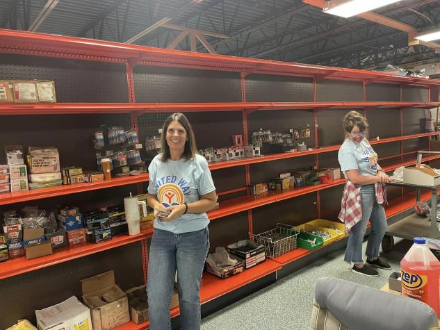 Two ladies organizing hardware items on shelves to sell