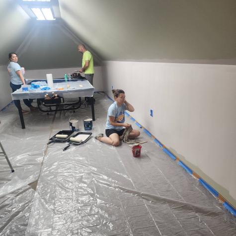 Group of people painting walls blue