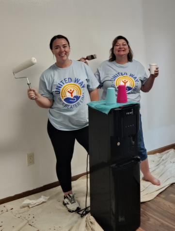 Two ladies in front of a mini fridge with painting supplies