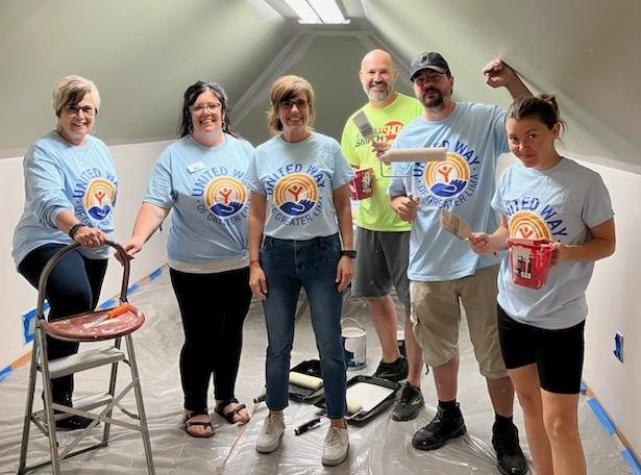 Group of people posing for a picture getting ready to paint