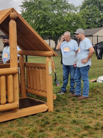 Two men building a log cabin playset